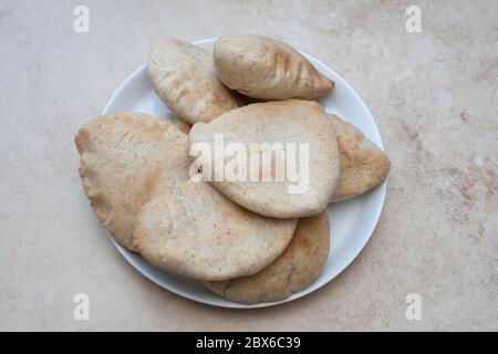 Fresh baked flat pitta breads served on a white dish Stock Photo