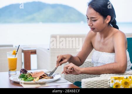woman eating at restaurant in luxury resort in Phuket - Thailand Stock Photo