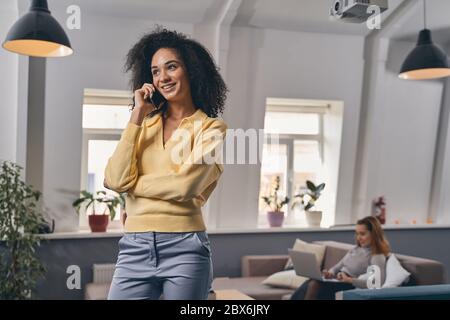Cheerful pretty lady talking on her smartphone Stock Photo
