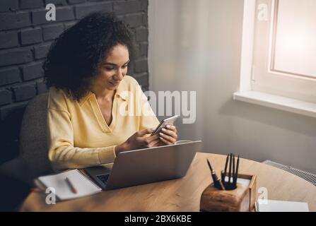 Smiling young lady sitting at the desk Stock Photo