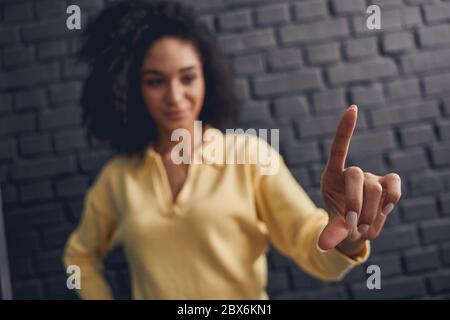 Dark-haired young female making a hand gesture Stock Photo