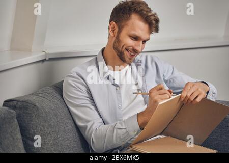 Young man taking notes in his notepad Stock Photo