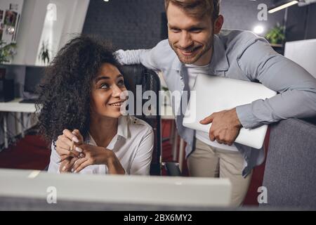 Man with a laptop standing next to his colleague Stock Photo