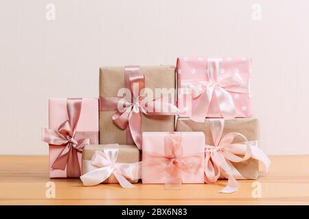 set of beautiful different gift boxes made by handmade with pink bows on a wooden table with a light background Stock Photo
