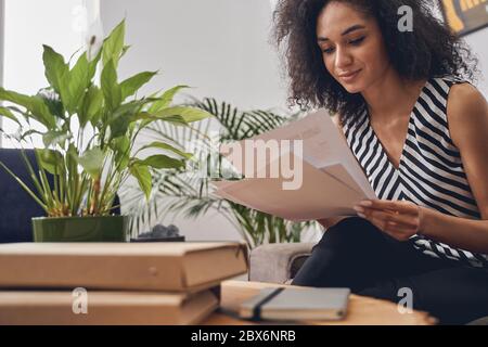 Concentrated woman analyzing the documents at the desk Stock Photo
