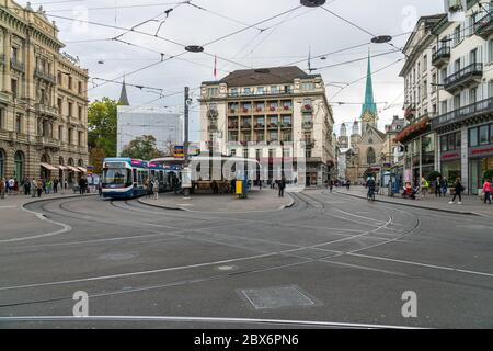 Zurich, Switzerland - October 6, 2018: People visiting the Paradeplatz square with its famous tram station, Savoy Hotel and a view to Fraumünster Stock Photo