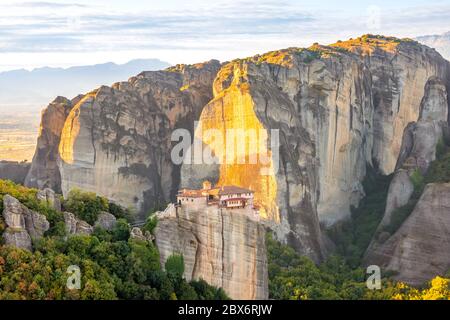 Greece. Sunny summer evening in a mountain valley. A stone monastery on top of a cliff Stock Photo