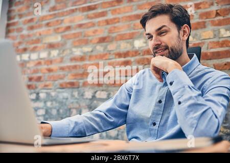 Happy man is using computer at workplace Stock Photo