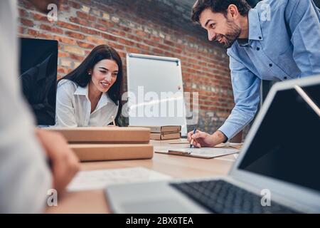 Happy coworkers writing notes while working together Stock Photo