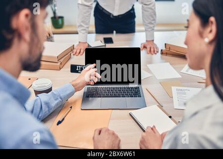 Teammates working in office and using laptop Stock Photo
