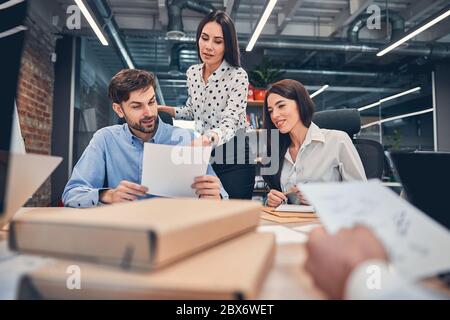 Co-workers discussing presentation of business project with boss in office Stock Photo