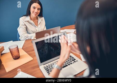 Two women sitting in office and working together Stock Photo