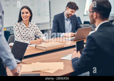 Teammates working in office and using gadgets and documents Stock Photo