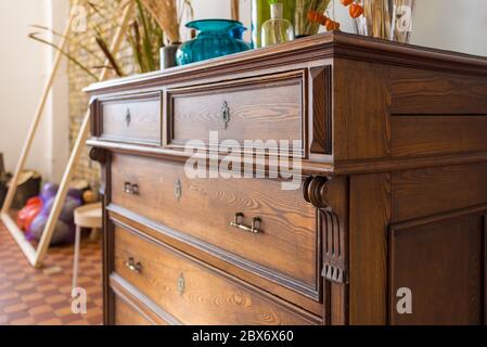 old antique old mahogany chest of drawers in a room with additional decor Stock Photo