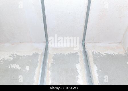 Aluminum profile for LED lighting placed in a wall with cement-lime plaster that goes into the ceiling in a newly built house. Stock Photo