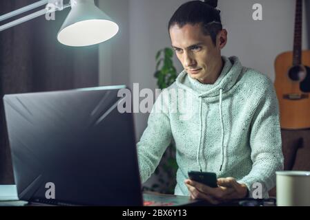 The man is working remotely using a laptop. Ability to work productively in home office mode for programmers, designers, and many other professionals Stock Photo
