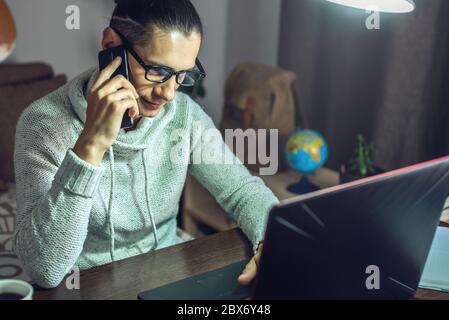 The man is working remotely using a laptop. A comfortable and convenient workplace at home for programmers, designers, and many other professionals Stock Photo