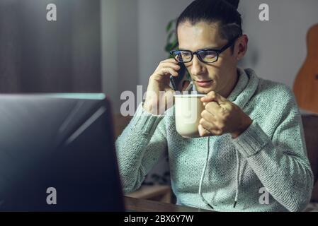 The man is working remotely using a laptop. Ability to work productively in home office mode for programmers, designers, and many other professionals Stock Photo