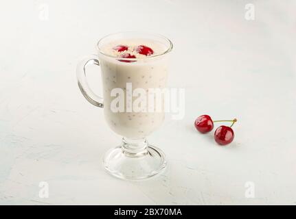 Chia yogurt pudding with coconut flakes and cherry berries. Healthy nutrition to restore strength and reduce weight. Chia and yogurt pudding in a glas Stock Photo