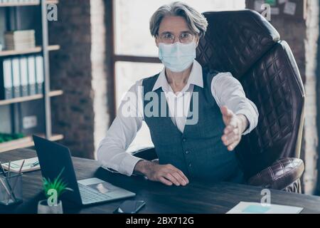 Portrait of his he attractive gray-haired director shaking hand inviting to start-up wearing gauze mask preventive measures cov ncov-2 infection at Stock Photo