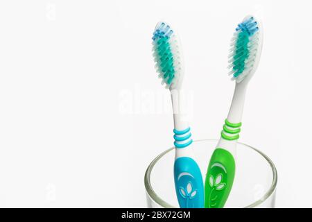 Set of colorful toothbrushes in glass on white background. Stock Photo