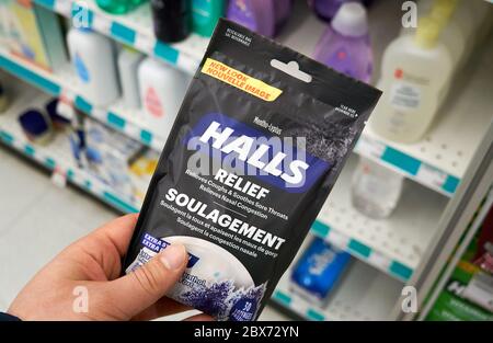 Montreal, Canada - May 03, 2020: Halls Mentho Lyptus drops pack in a hand. Halls is the brand name of a popular mentholated cough drop. Halls cough dr Stock Photo