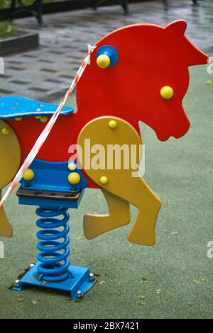 An empty playground without children with striped red and white warning tape, limitations quarantined for Covid19 coronavirus Stock Photo