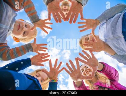 A friendly large family makes a circle shape out of the palms of their hands. Stock Photo