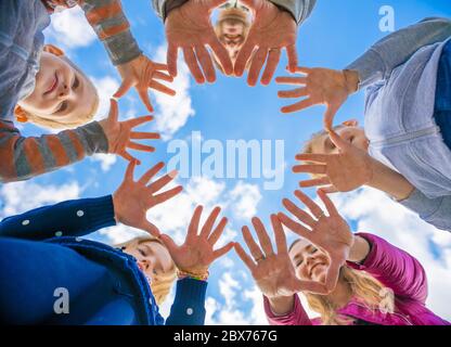 A friendly large family makes a circle shape out of the palms of their hands. Stock Photo