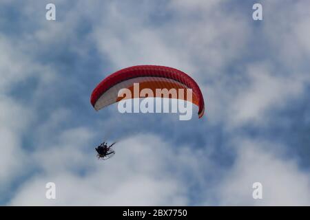 Moto parasailing on a background of blue sky with white clouds
