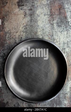 Empty rustic black plate on slate background, top view. Stock Photo