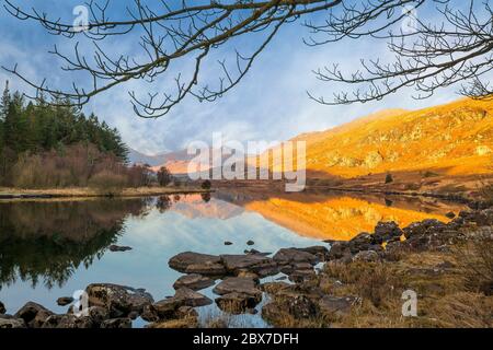 Scenic view of the Snowdon Horseshoe mountains at sunrise, reflected in the still water of Llynnau Mymbyr, Snowdonia National Park, North Wales, UK. Stock Photo