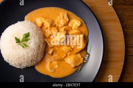 Chicken strogonoff with rice and french fries (potato sticks) on dish. Chicken stroganoff, is a dish originating from Russian cuisine that in Brazil i Stock Photo