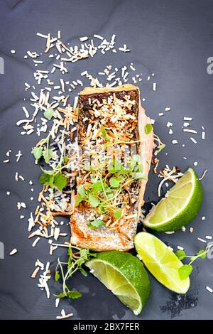 Salmon grilled with lime and toasted coconut.  Garnished with micro herbs. Stock Photo