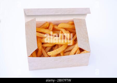 Pile of delicious golden and crunchy french fries in an open box made from sustainable cardboard. Isolated on white background. Stock Photo