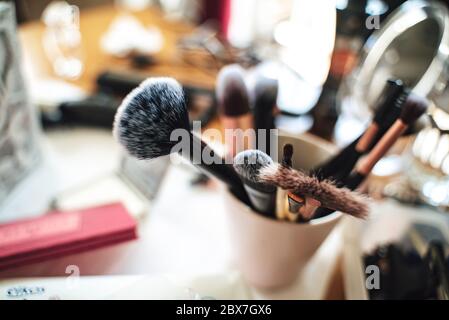 Makeup cosmetics and accessories for makeup. Various makeup brushes on cosmetic table. Female beauty concept. Stock Photo