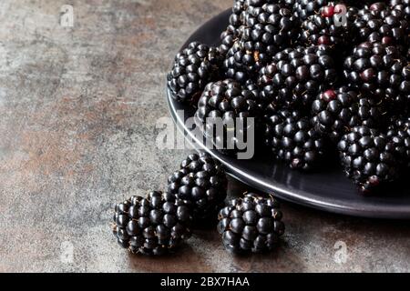 Fresh blackberries on a black plate, over slate. Stock Photo