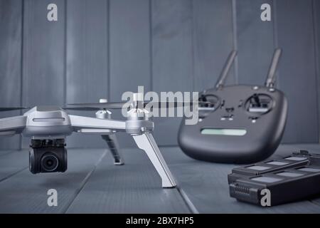 Close-up of propellers and batteries and high resolution camera of a four-engine drone with radio control equipment in the background Stock Photo