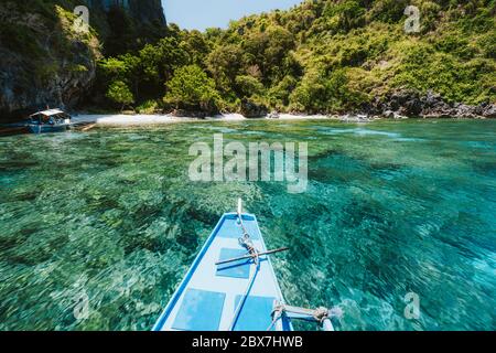 Trip tourist boat in blue shallow water lagoon. Discover exploring unique nature, journey to paradise approaching tropical island Stock Photo