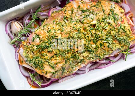 Raw lamb shoulder ready for slow roasting.  Top View, with rosemary, onions, garlic, mustard and balsamic. Stock Photo