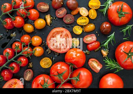 Tomato varieties on black iron.  Overhead view. Stock Photo