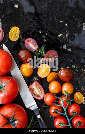 Tomato varieties on black iron.  Overhead view. Stock Photo