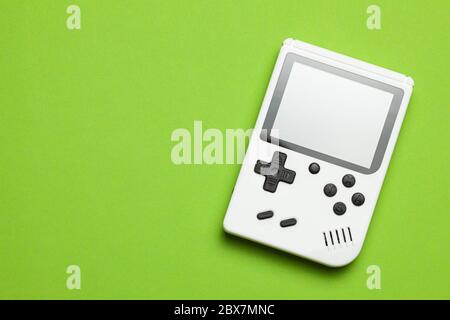 Old game console. Gamepad is white on a green background. Copy space for text Stock Photo
