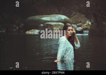 Beautiful woman in the green waters of a mountain stream . Fantasy and surreal Stock Photo