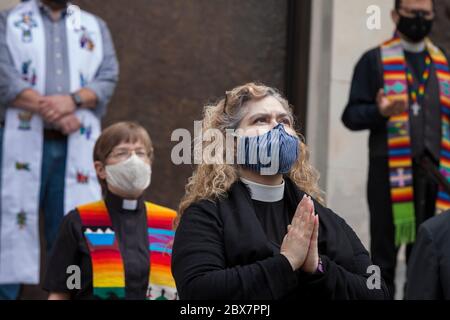 Members of the clergy pray while the funeral bell tolls during a vigil at St. James Cathedral in Seattle on Friday, June 5, 2020. Clergy from many faith traditions gathered for 'A Moment of Prayer and Lament' to pray and observe eight minutes, 46 seconds of silence in remembrance of George Floyd. Stock Photo