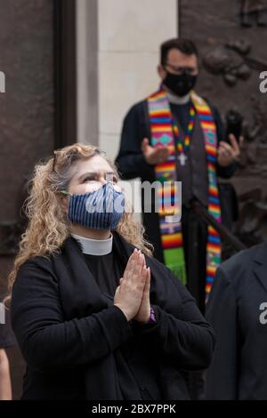 Members of the clergy pray while the funeral bell tolls during a vigil at St. James Cathedral in Seattle on Friday, June 5, 2020. Clergy from many faith traditions gathered for 'A Moment of Prayer and Lament' to pray and observe eight minutes, 46 seconds of silence in remembrance of George Floyd. Stock Photo