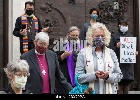 Members of the clergy pray while the funeral bell tolls during a vigil at St. James Cathedral in Seattle on Friday, June 5, 2020. Clergy from many faith traditions gathered for 'A Moment of Prayer and Lament' to pray and observe eight minutes, 46 seconds of silence in remembrance of George Floyd. Stock Photo