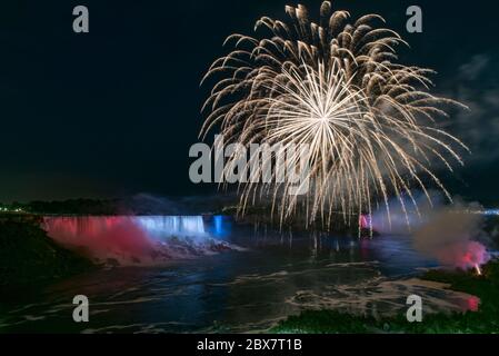 July 4th fireworks at Niagara Falls with American Falls and Bridal Veil Falls lighted red, white, and blue Stock Photo