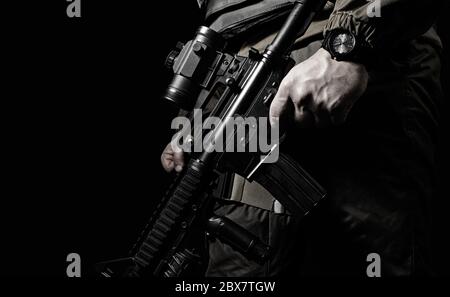 Closeup black and white photo of equipped swat soldier holding a rifle profile view. Stock Photo