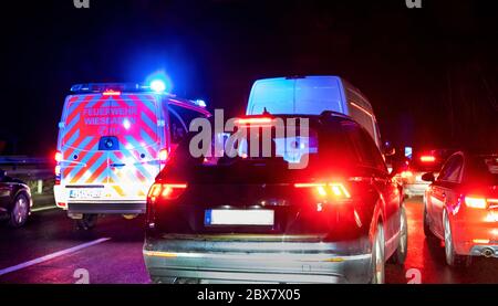 Highway A3, Germany, 03/01/2020: Motorway traffic jam due to accident on a wet road. Vehicles form an emergency lane for a fire truck.. Stock Photo